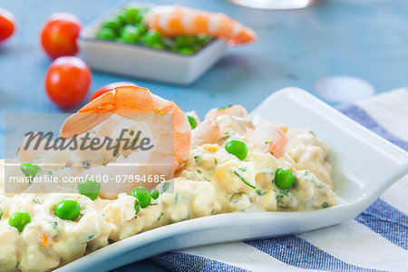 potato salad with prawn and peas on white plate