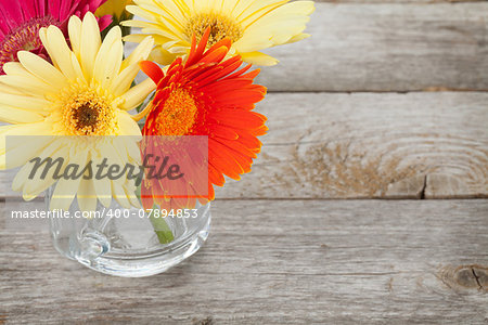Colorful gerbera flowers on wooden table with copy space
