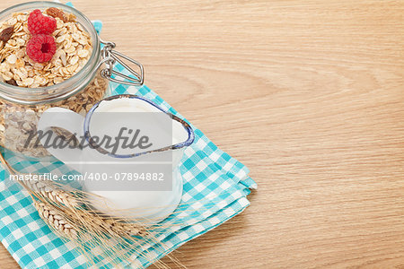 Healty breakfast with muesli, berries and milk. On wooden table with copy space