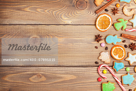 Christmas wooden background with candies, spices, gingerbread cookies and copy space