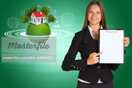 Beautiful businesswoman in suit holding paper holder. Earth with house and trees in background