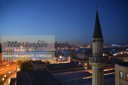 This is the evening view of Bosphorus, Istanbul.Streets and buildings are illuminated and reflect in the water.