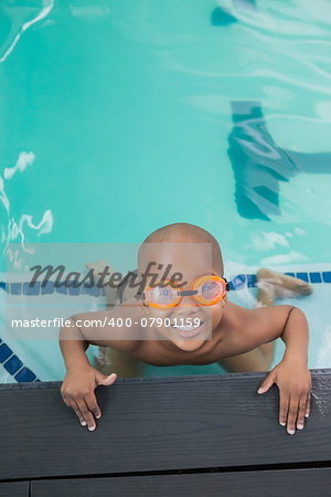 Cute little boy smiling up at the pool at the leisure center
