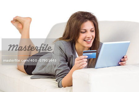 Woman doing online shopping with tablet and credit card at home in the living room