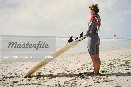 Surfer with surfboard on beach, Lacanau, France