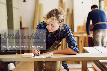 Young craftswoman making notes in pipe organ workshop Young craftswoman making notes in pipe organ workshop