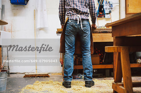 Cropped view of mature craftsman at workbench in pipe organ workshop