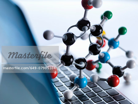 Molecular model sitting on top of lap top computer keyboard to illustrate science education and computer aided research