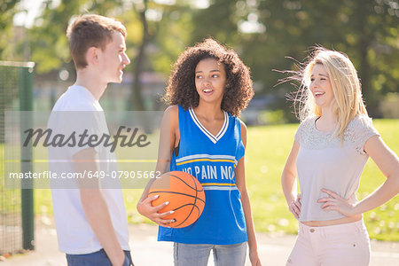 Three young adult basketball players chatting