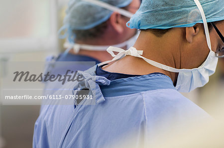 Doctors wearing surgical caps, masks and scrubs in operating theater