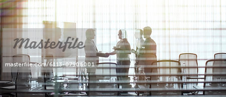 Business people standing in conference room shaking hands Business people standing in conference room shaking hands