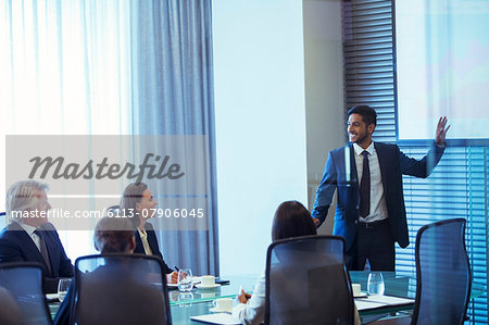 Businessman giving presentation to colleagues in conference room Businessman giving presentation to colleagues in conference room