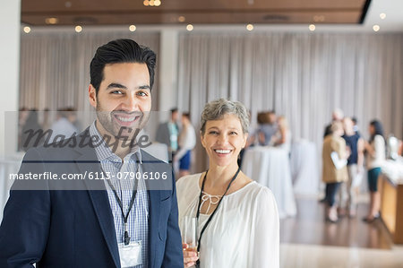 Portrait of man and woman standing in lobby of conference center smiling