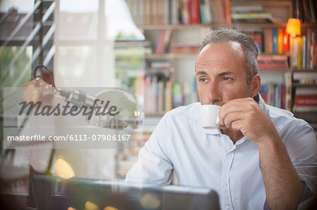 Businessman drinking cup of espresso in home office