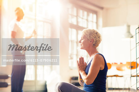 Older woman meditating on floor Older woman meditating on floor