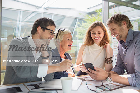 Business people using cell phone in office meeting