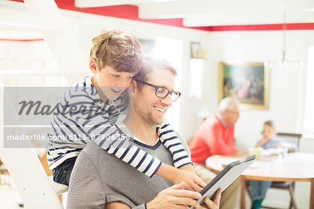 Father and son using digital tablet