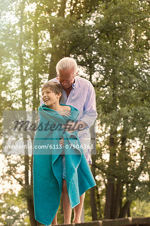 Grandfather drying grandson with towel