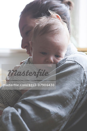 Portrait of mother holding little baby in striped t-shirt