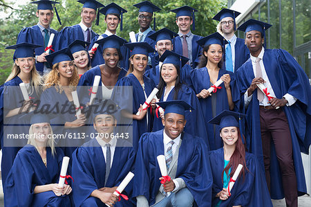 Portrait of university students in graduation gowns outdoors