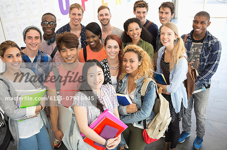Group portrait of university students standing together in corridor