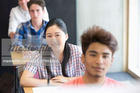 Portrait of smiling university students sitting in classroom