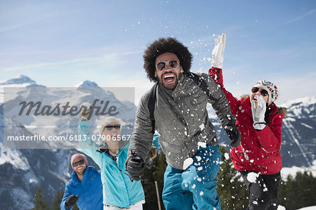 Friends enjoying snowball fight at mountain