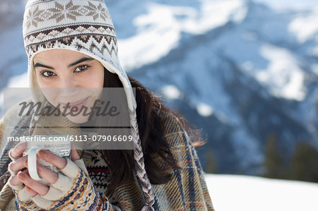Portrait of woman drinking hot cocoa in snow