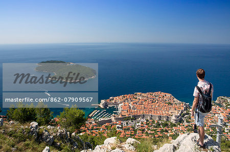 Europe, Croatia, Dalmatia, Dubrovnik, a tourist looking out over the historic centre of town  - the Old City of Dubrovnik Unesco World Heritage site - the Adriatic and the adjacent coast, Model Released, MR