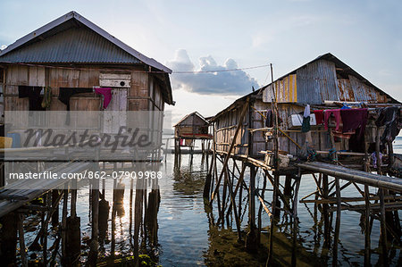 Indonesia, Flores Island, Wuring. The attractive wooden houses at Wuring Fishing Village are built on stilts above the sea and approached on stout bamboo walkways.