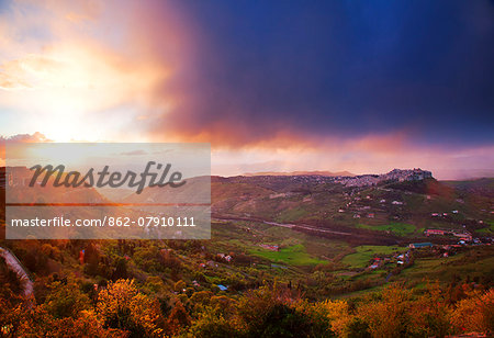 Italy, Sicily, Enna Province. View of the part of Enna old town and surroundings in dramatic evening light.