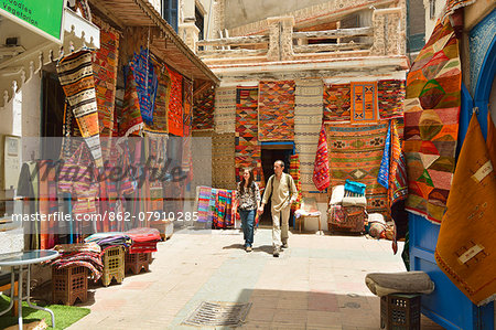 Young couple with Moroccan rugs in Essaouira. Morocco (MR)