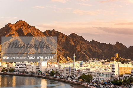 Oman, Muscat. Cityscape of Mutrah old town, elevated view, at sunset