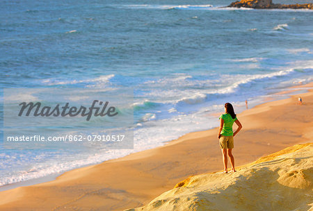 Portugal, Estramadura, Santa Cruz, Woman watching waves (MR)