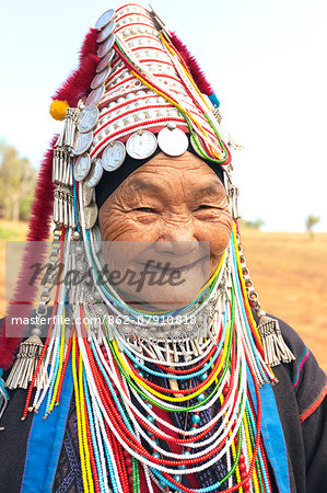 Thailand, Chiang Rai. Portrait of woman of Ahka tribe wearing traditional dress and headgear with silver coins (MR)