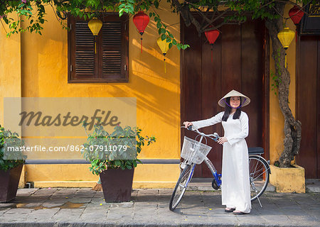 Woman wearing Ao Dai dress with bicycle, Hoi An (UNESCO World Heritage Site), Quang Ham, Vietnam (MR)