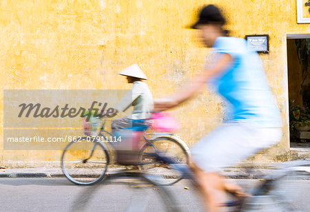 Vietnam, Hoi An. Local people on bicycle in the streets of the town