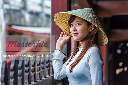 Vietnam, Hoi An. Young vietnamese girl with Ao Dai dress in front of famous japanese covered bridge (MR) Vietnam, Hoi An. Young vietnamese girl with Ao Dai dress in front of famous japanese covered bridge (MR)