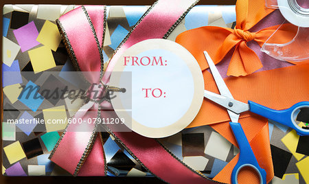 Wrapped present with scissors, tape and ribbon Wrapped present with scissors, tape and ribbon