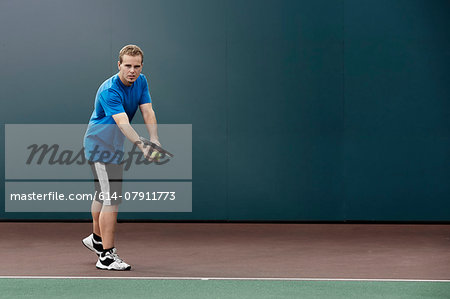 Tennis player about to serve ball in tennis court