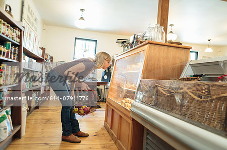 Female customer leaning to look at display cabinet in country store