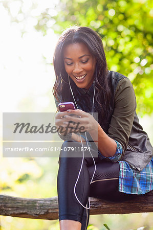Young woman using smartphone on park bench