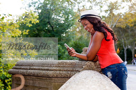 Young woman using smartphone, Central Park, New York, USA