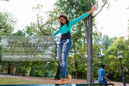 Woman balancing on railing in park