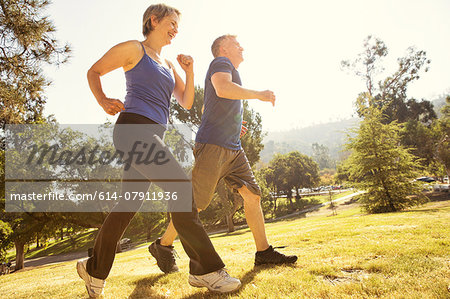 Mature couple power walking in park