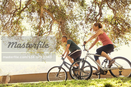 Mature couple cycling in park Mature couple cycling in park