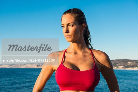 Portrait of young woman wearing sports top, on beach