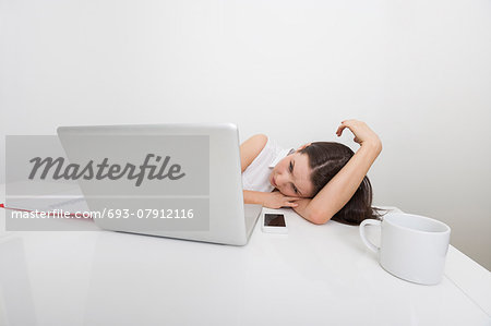 Bored businesswoman looking at laptop in office