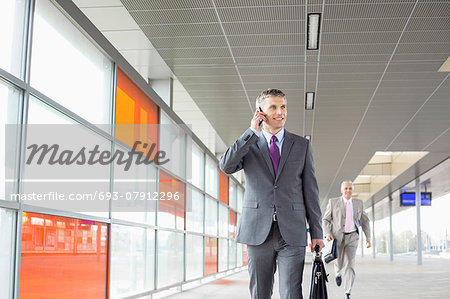 Middle aged businessman on call while walking in railroad station