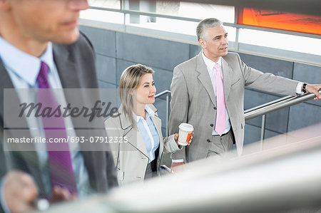 Businesspeople walking up stairs in train station